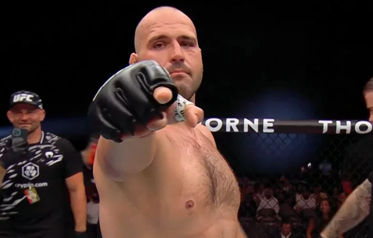 UFC heavyweight Martin Buday points toward the camera inside the octagon after a fight. The text reviews his 7-1 UFC record, including wins over Andrei Arlovski, Uran Satybaldiev, and Marcus Buchecha.
