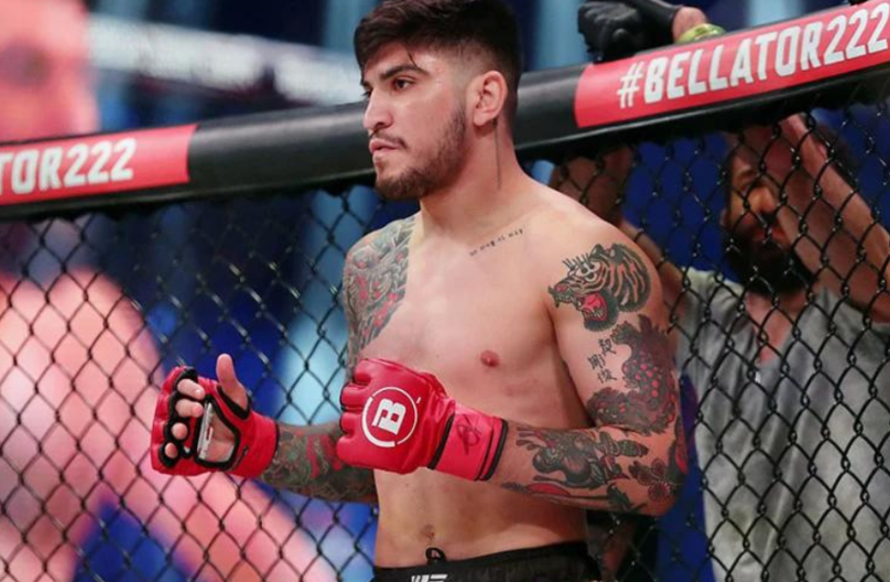 Dillon Danis stands inside the Bellator cage with gloves on, representing his MMA credentials ahead of the potential Eddie Hall fight.
